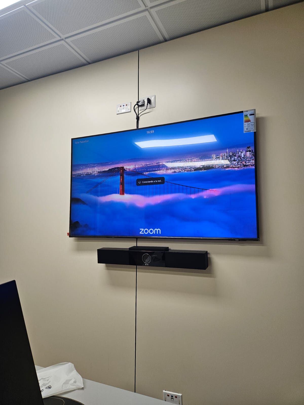 Sala corporativa con doble pantalla y barra de videoconferencia